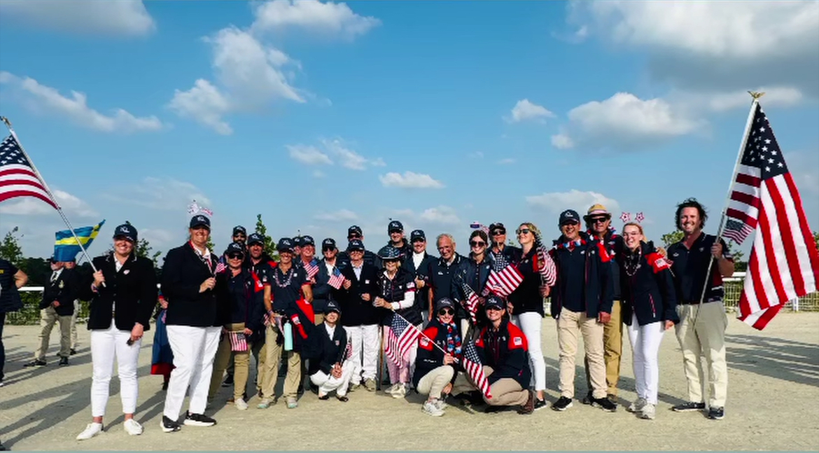 Large group together for team USA holding flags