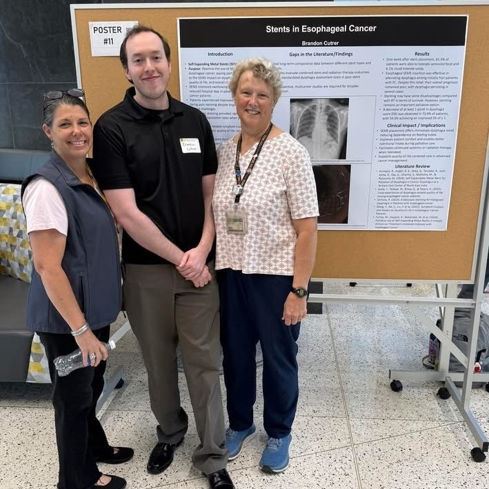 Melanie Dempsey and Timmerie Cohen with Brandon Cutrer in front of his poster Stents in Esophageal Cancer